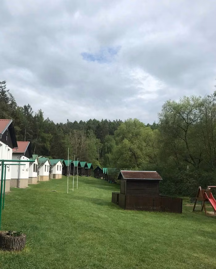 Pohled na areál s chatkami a okolními lesy