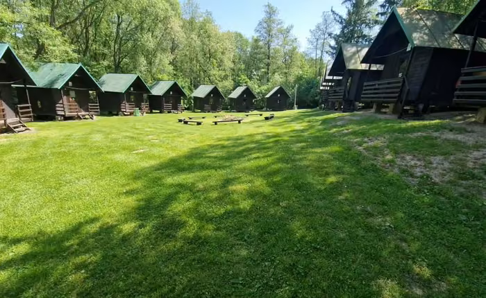 Řada dřevěných chatek se zelenými střechami